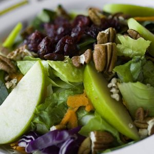 Salmón a la plancha sobre lechugas mixtas y zanahoria en ensalada